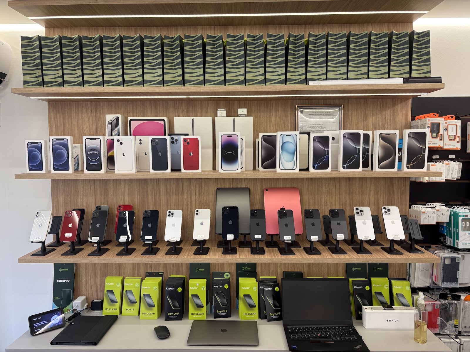 Interior da loja NG SHOP em Joinville, com prateleiras de iPhones, iPads e acessórios Apple